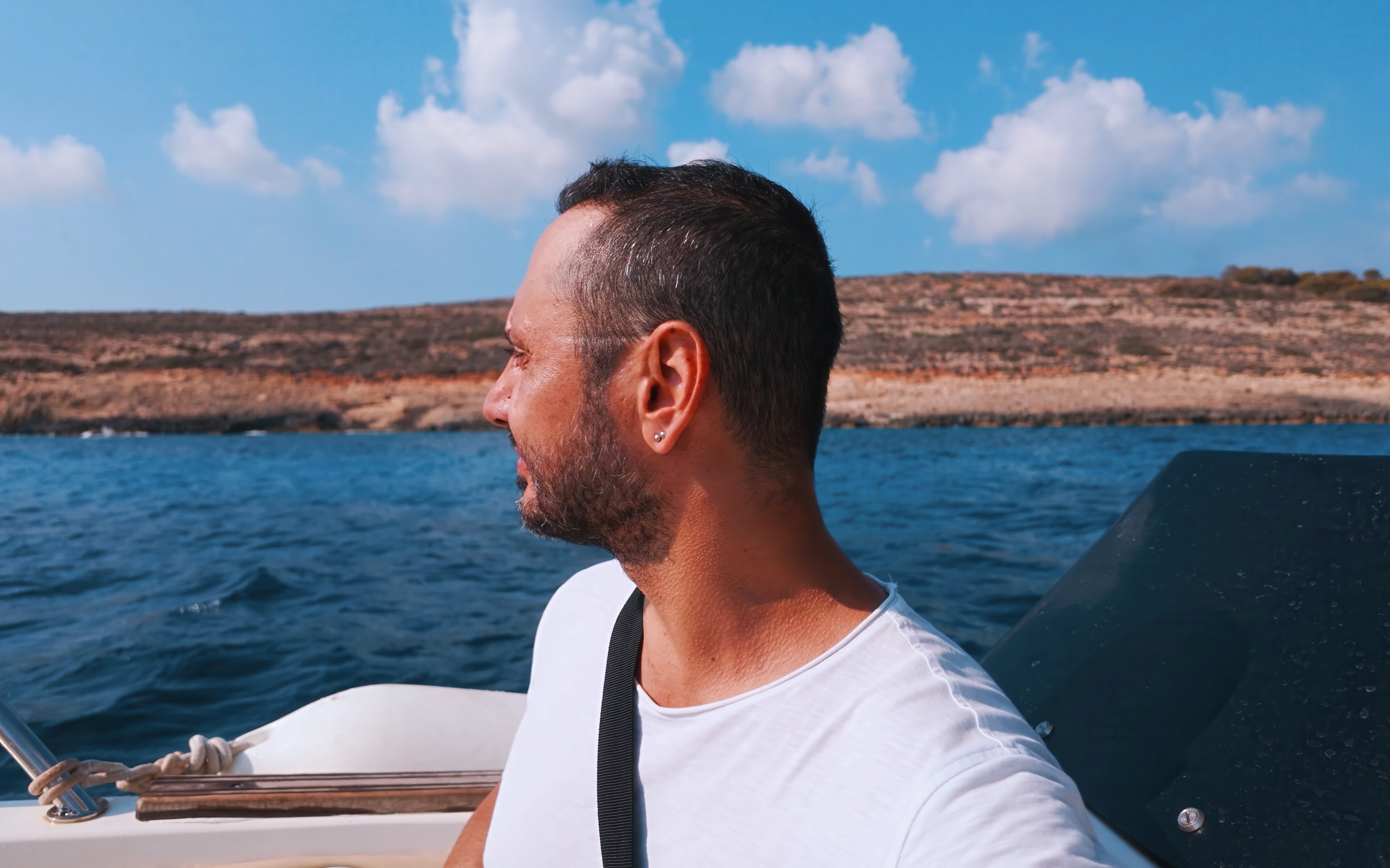 Man enjoying a boat ride on the Fernandes Gozo & Comino all-inclusive cruise.