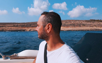 Man enjoying a boat ride on the Fernandes Gozo & Comino all-inclusive cruise.