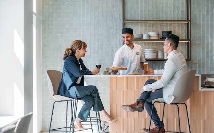 Server presenting food to guests at Plaza Premium Lounge, International Arrival.