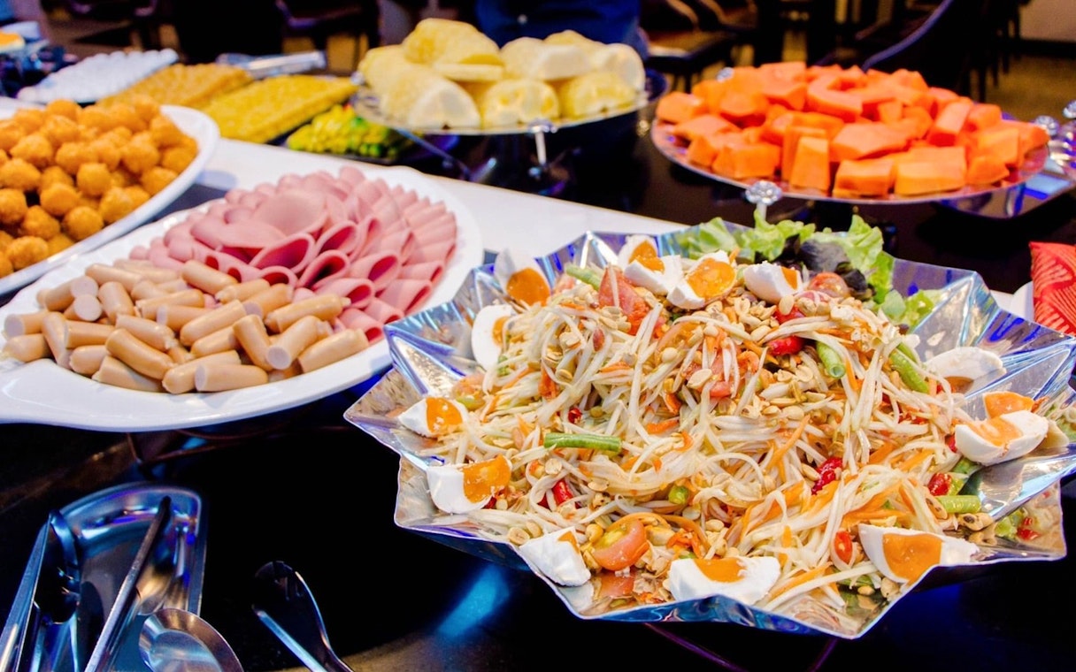 Buffet spread on Royal Princess Cruise featuring salad, cold cuts, and tropical fruits.