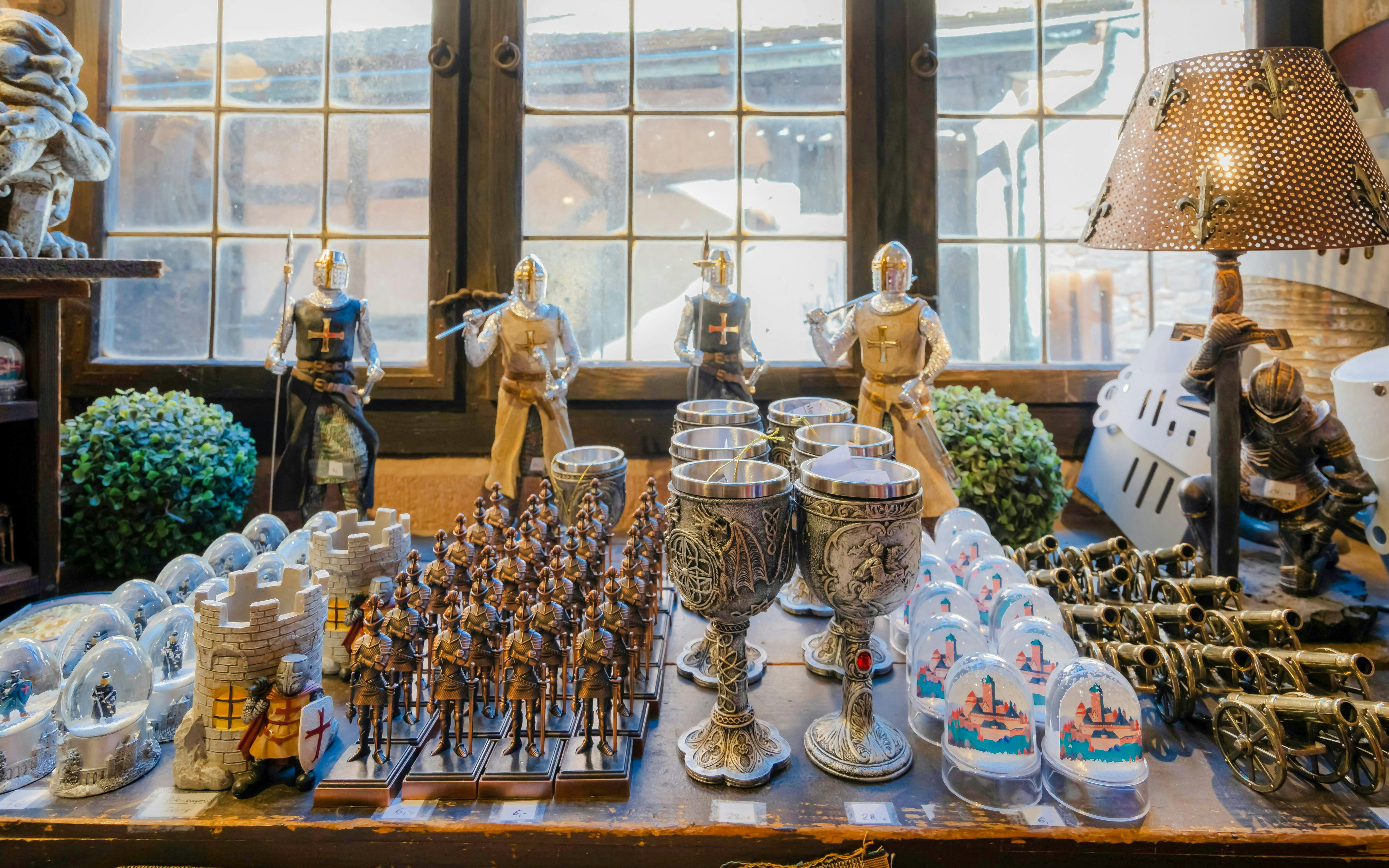 Medieval knight figurines and goblets on display at Haut-Koenigsbourg gift shop.
