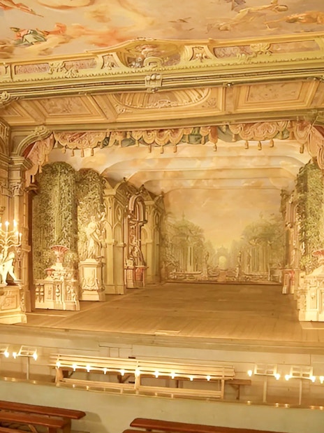Baroque castle theatre interior in Cesky Krumlov with ornate stage and seating.