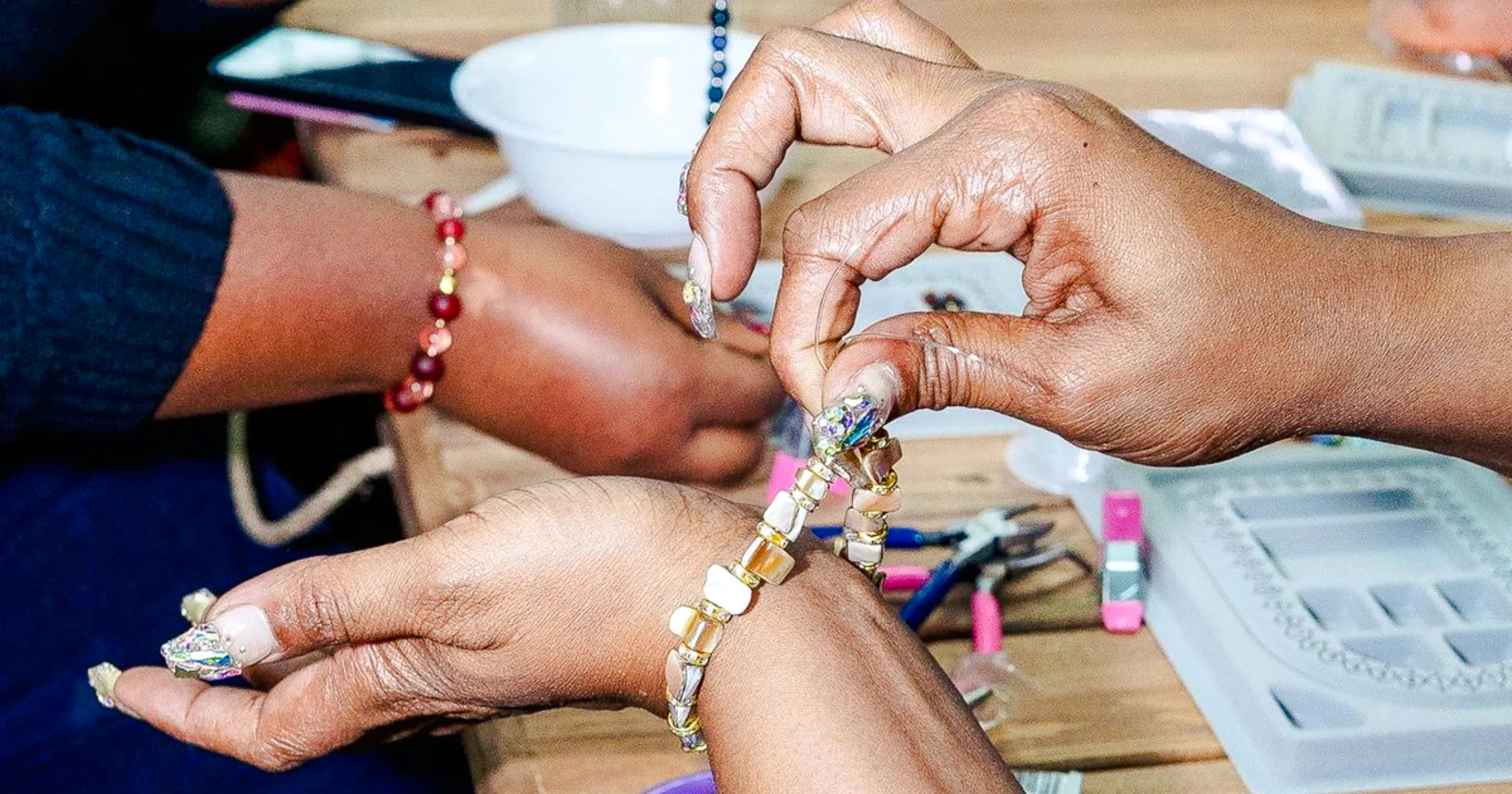 Hands crafting a bracelet at a handmade jewellery workshop in Essaouira.