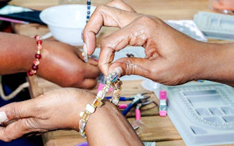 Hands crafting a bracelet at a handmade jewellery workshop in Essaouira.
