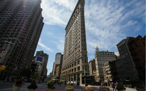 Flatiron Building in New York City under a blue sky, part of the Secrets of the Skyline tour.