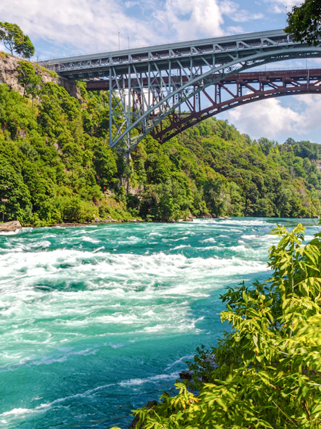 Rapids in the Niagara River near the whirlpool with a bridge in the background.