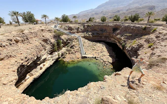 Wadi Shab and Bimmah Sinkhole with stairs and visitor, Muscat tour.
