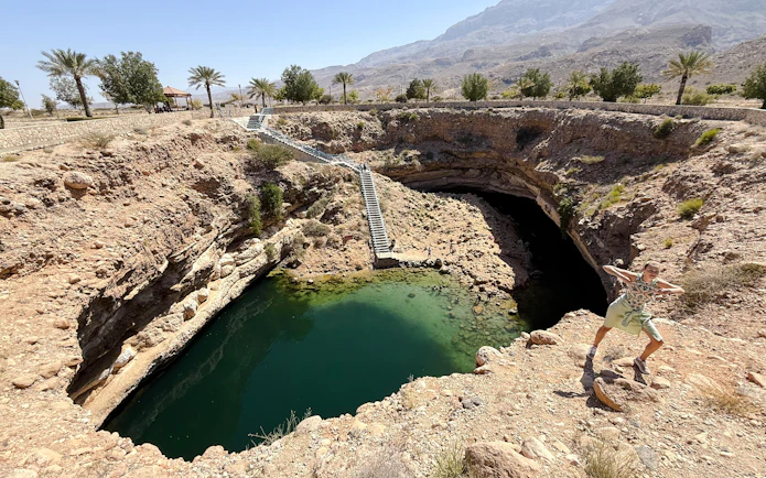 Wadi Shab and Bimmah Sinkhole with stairs and visitor, Muscat tour.