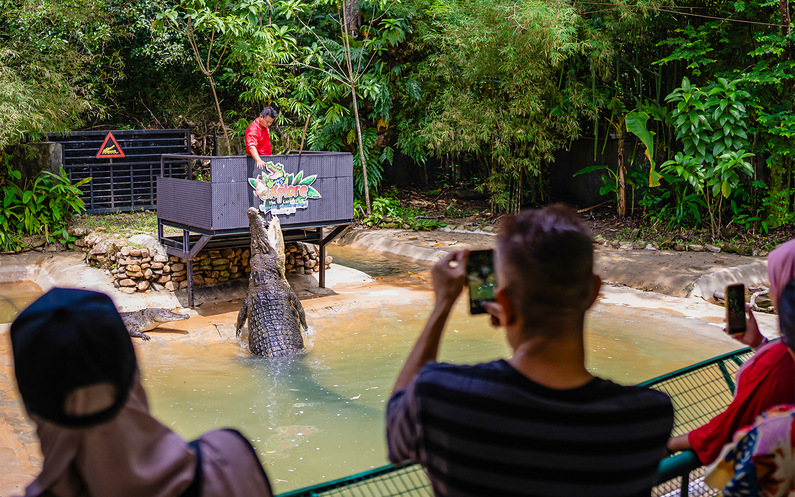 Crocodile feeding show at Crocodile Adventureland Langkawi with visitors watching.