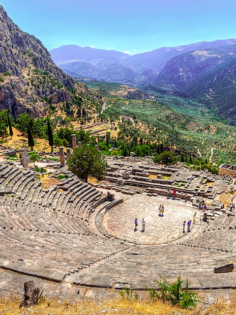 Ancient Theater in Delphi with mountainous landscape in the background.