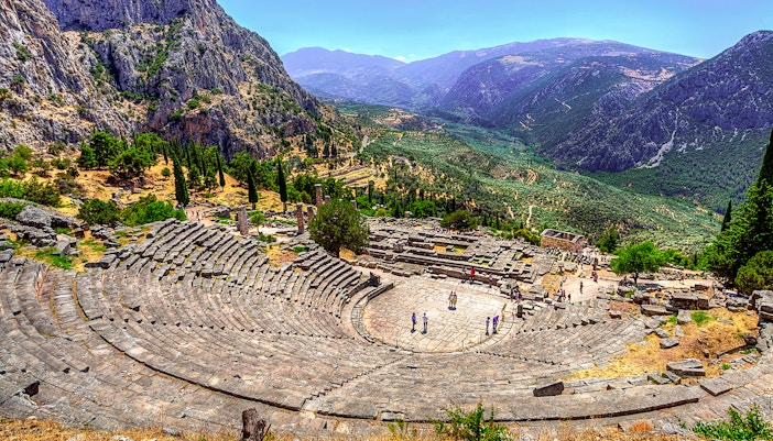 Ancient Theater in Delphi with mountainous landscape in the background.