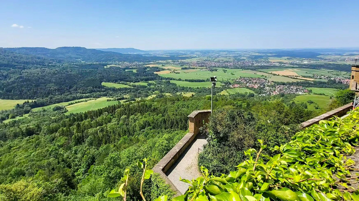 View from Hohenzollern Castle overlooking lush green landscape and distant hills, Germany.