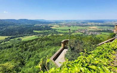 View from Hohenzollern Castle overlooking lush green landscape and distant hills, Germany.