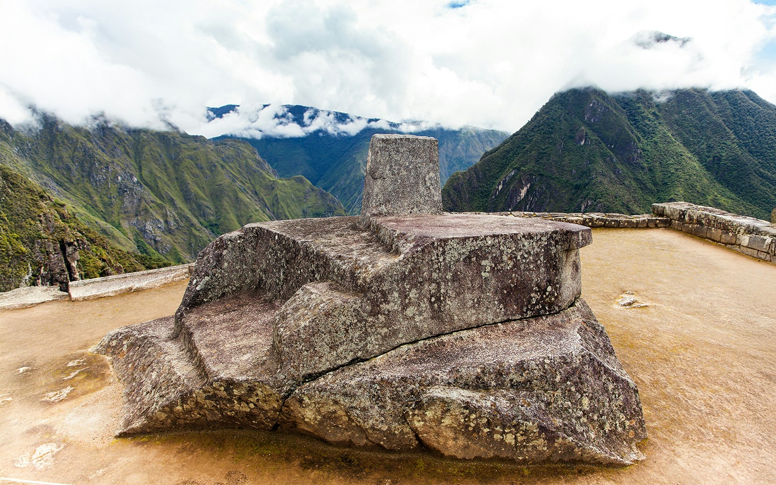 Machu Picchu with Intihuatana stone in Peru, showcasing ancient Incan architecture and mountainous landscape.