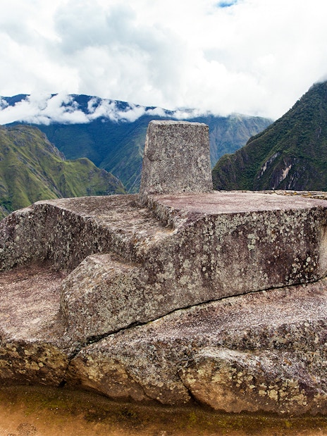 Intihuatana stone at Machu Picchu with Andes mountains in the background, Peru.