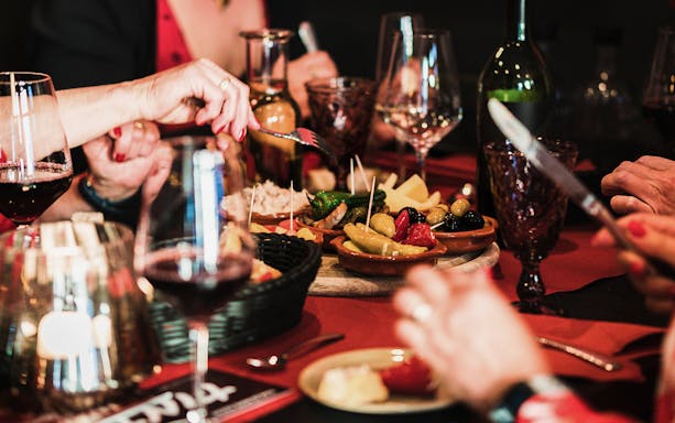 Dining table with tapas and wine during a walking tour in Triana, Seville.