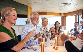 Group dining on a Sydney Harbour cruise with wine and scenic views.