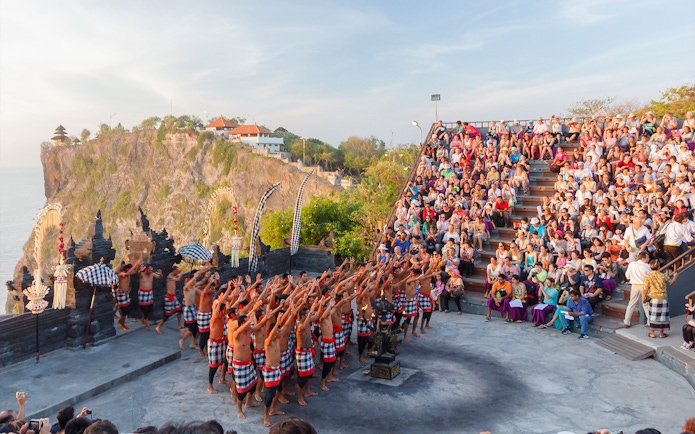 Kecak dance performance at Uluwatu Temple, Bali, with a large audience in attendance.