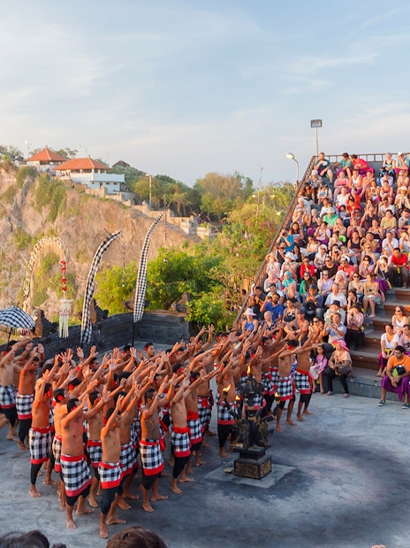 Kecak dance performance at Uluwatu Temple, Bali, with a large audience in attendance.
