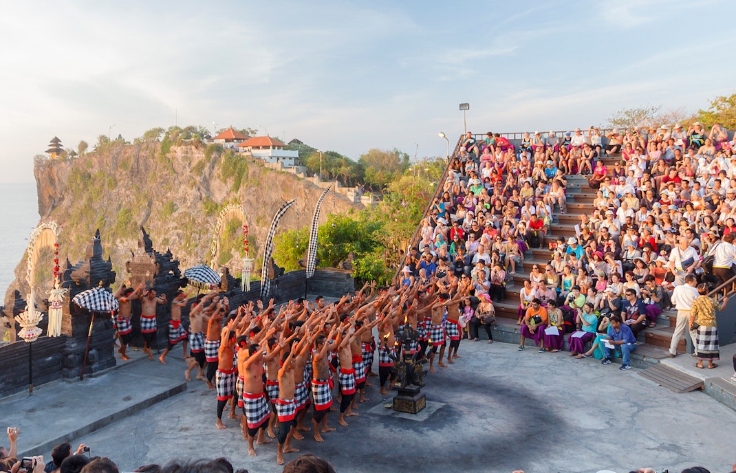 Kecak dance performance at Uluwatu Temple, Bali, with a large audience in attendance.