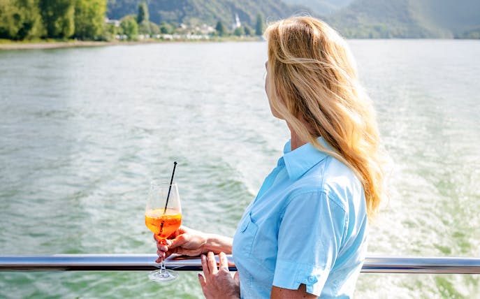 Woman enjoying a drink on a Koblenz sightseeing cruise.