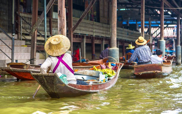 Vendor selling food from a boat at Pattaya Floating Market, Thailand.