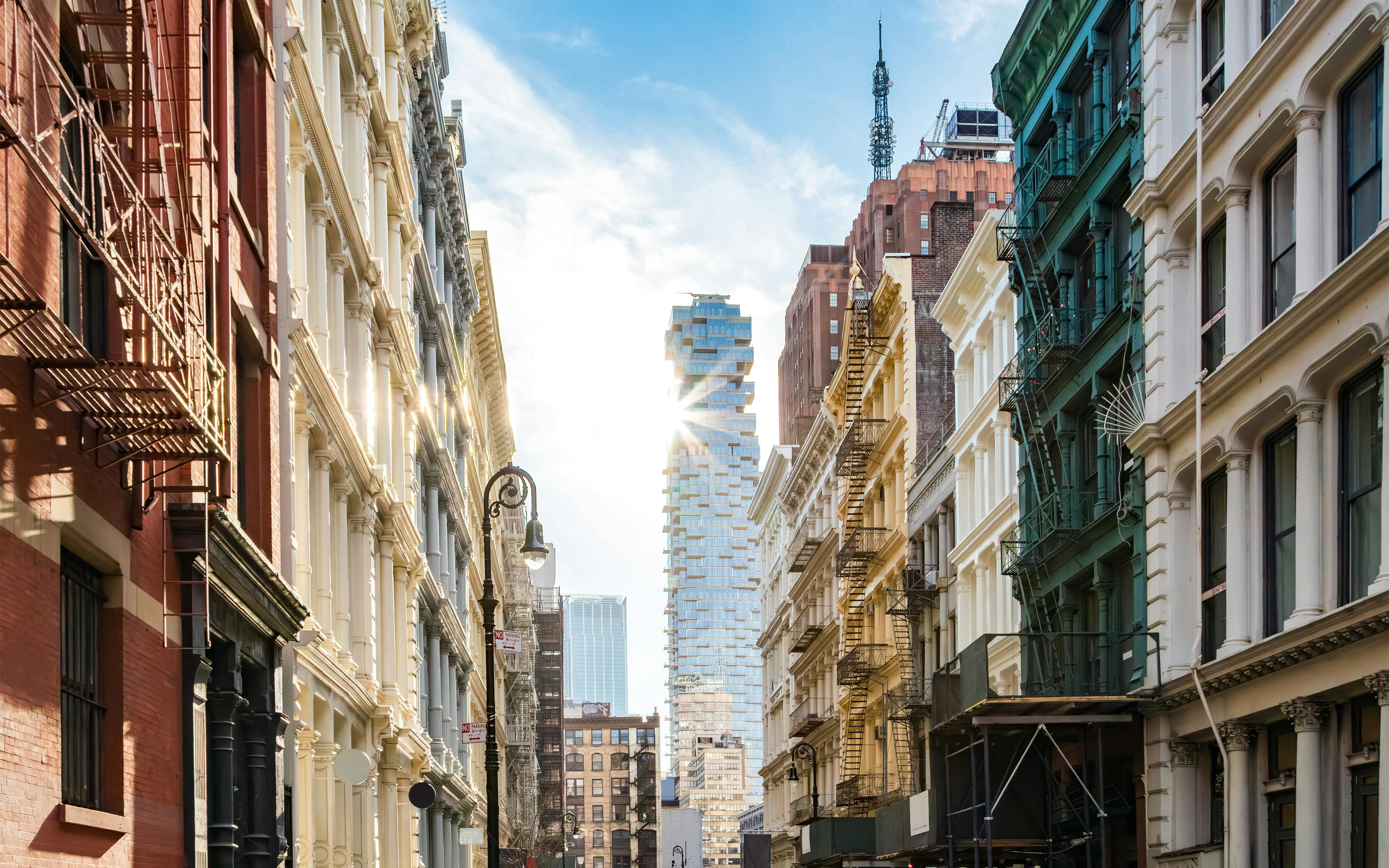 Historic buildings and modern skyscraper on Greene Street, SoHo, New York City.