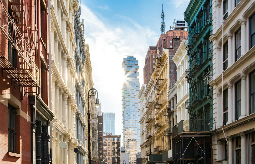 Historic buildings and modern skyscraper on Greene Street, SoHo, New York City.