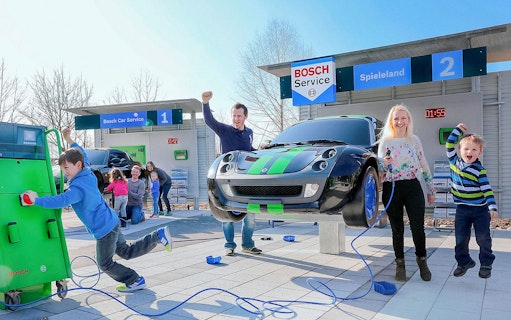 Children and adults enjoying interactive car-themed attraction at Ravensburger Spieleland.