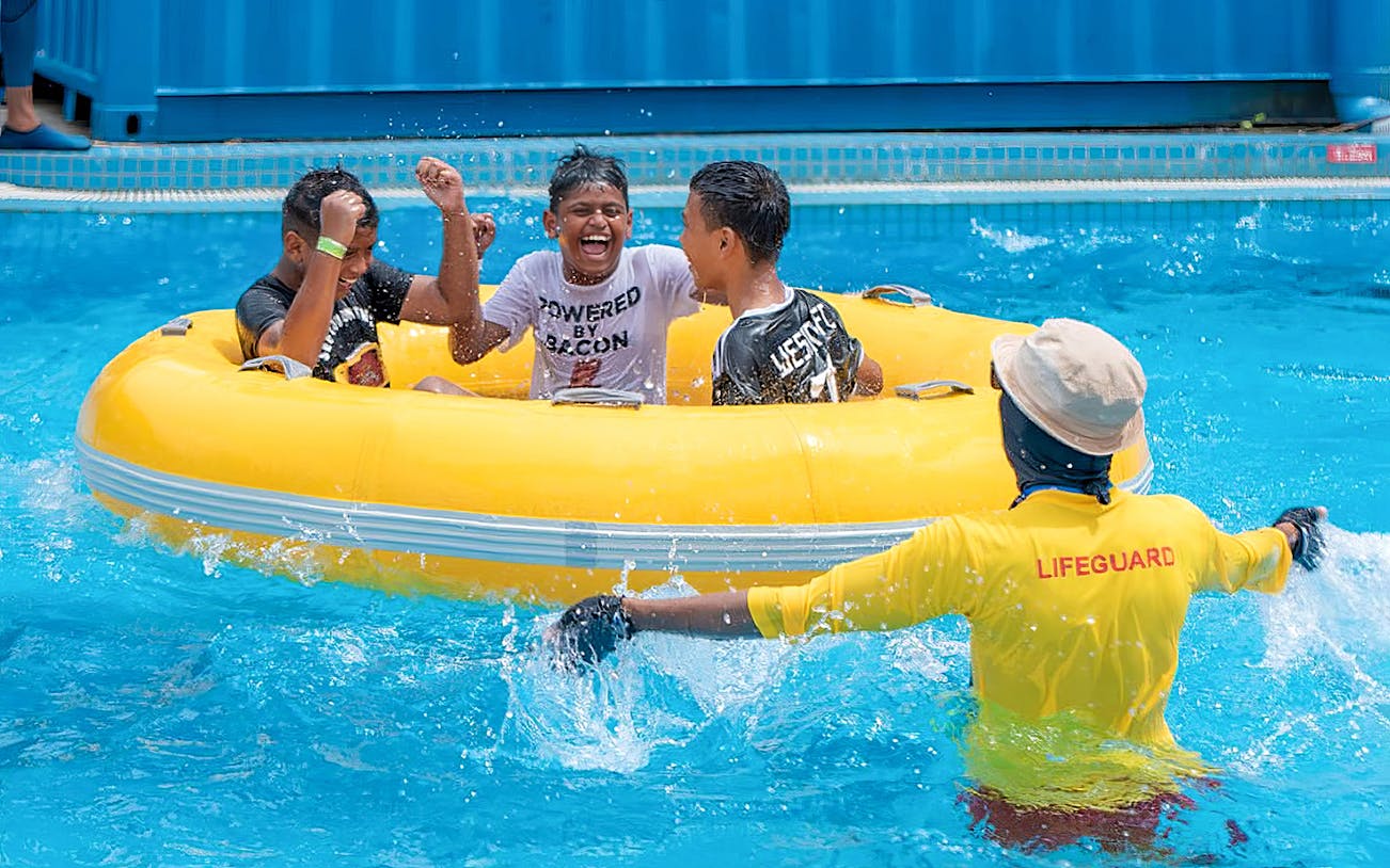 Group enjoying a yellow raft ride at Splash Out Langkawi Water Theme Park.
