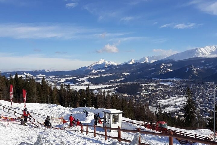 View of Tatra Mountains from Gubałówka summit, Zakopane, showcasing scenic landscape and lush greenery.