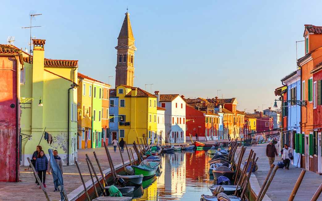 Colorful houses and canal with boats on Burano Island, Italy.