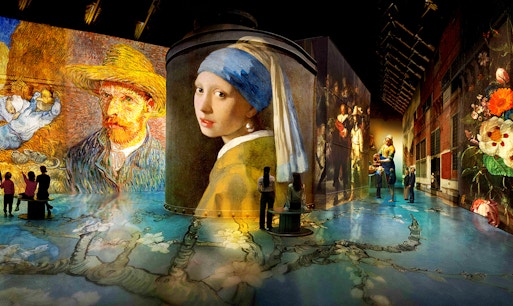 Visitors viewing Dutch Masters artworks at Fabrique des Lumières exhibition in Amsterdam.