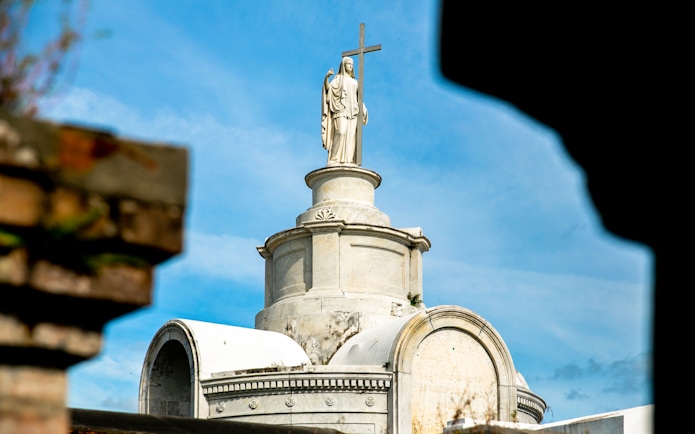 Tomb with statue and cross in St. Louis Cemetery, New Orleans.