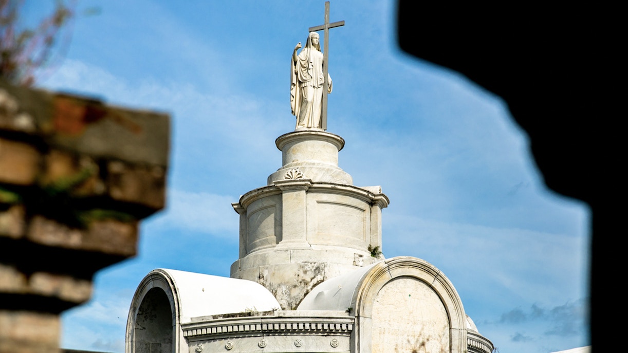 Tomb with statue and cross in St. Louis Cemetery, New Orleans.