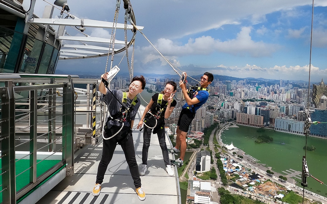 Visitors enjoying the Skypark Macau by AJ Hackett with cityscape view.