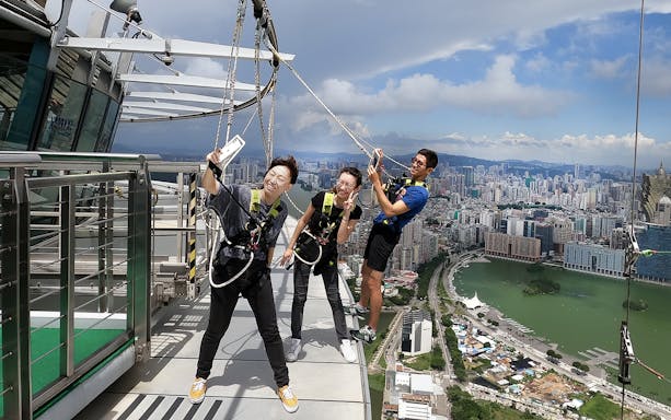 Visitors enjoying the Skypark Macau by AJ Hackett with cityscape view.