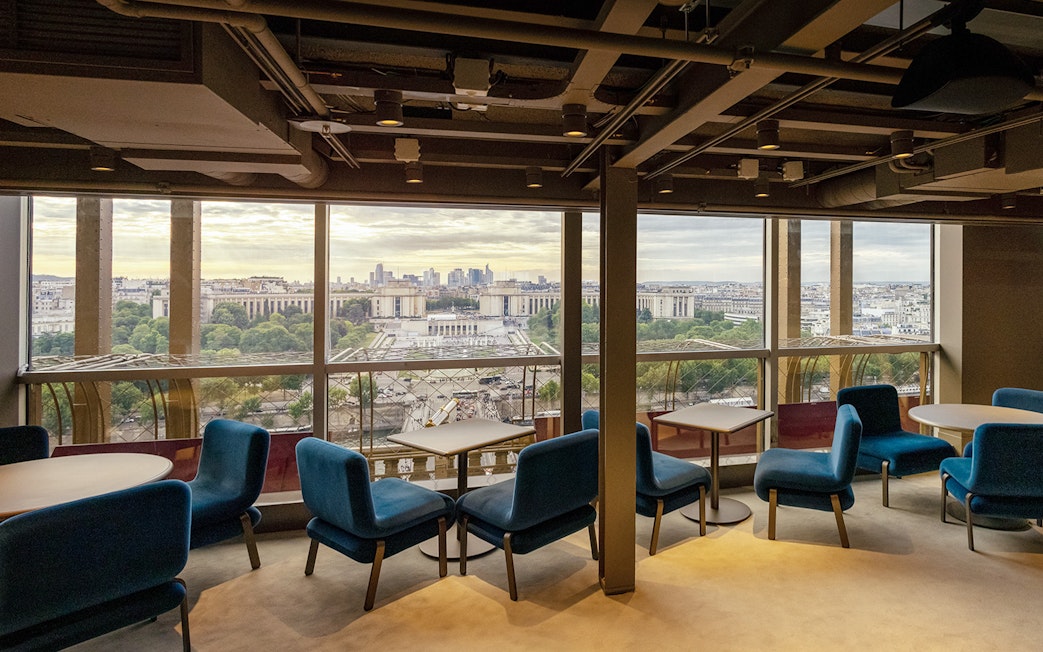 Eiffel Tower restaurant interior with Paris cityscape view.