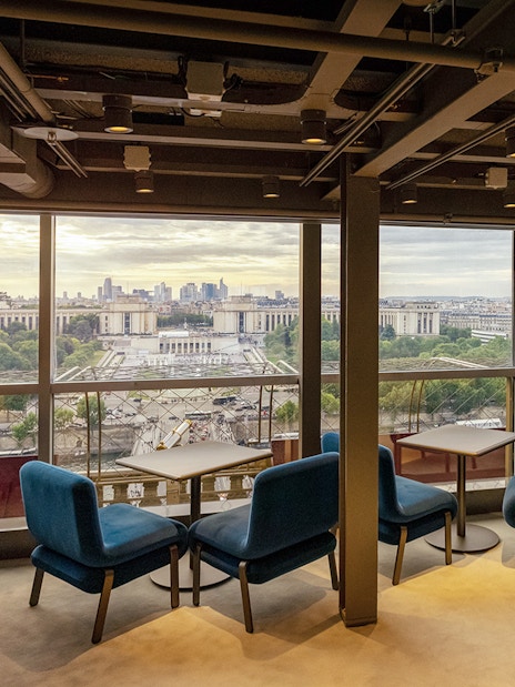 Eiffel Tower restaurant interior with Paris cityscape view.