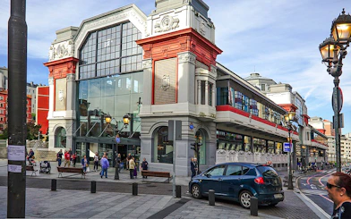 Bilbao's Ribera Market exterior with people walking, part of San Sebastian tour.