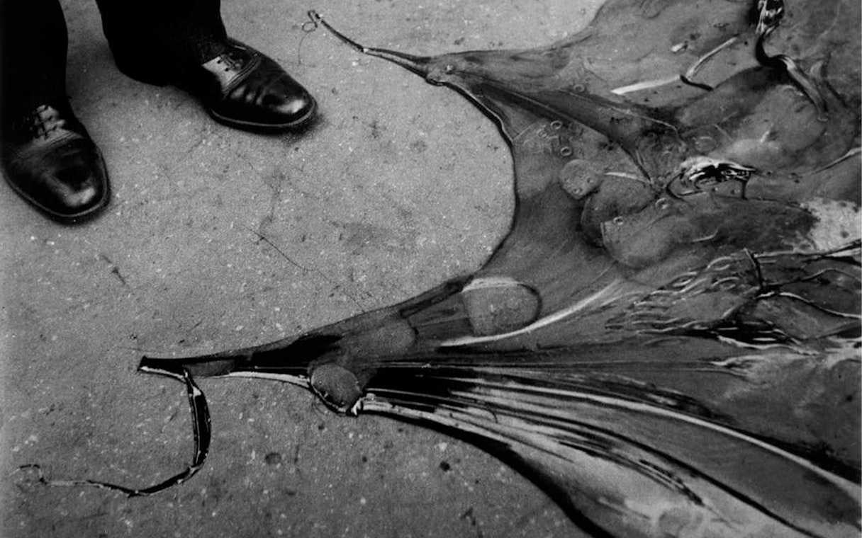 Shoes beside a broken umbrella on the ground at Lee Miller exhibition, Tate Britain.