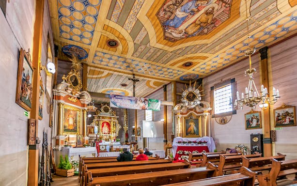 Interior of a historic church in Krakow's Old Town with ornate ceiling and altar.