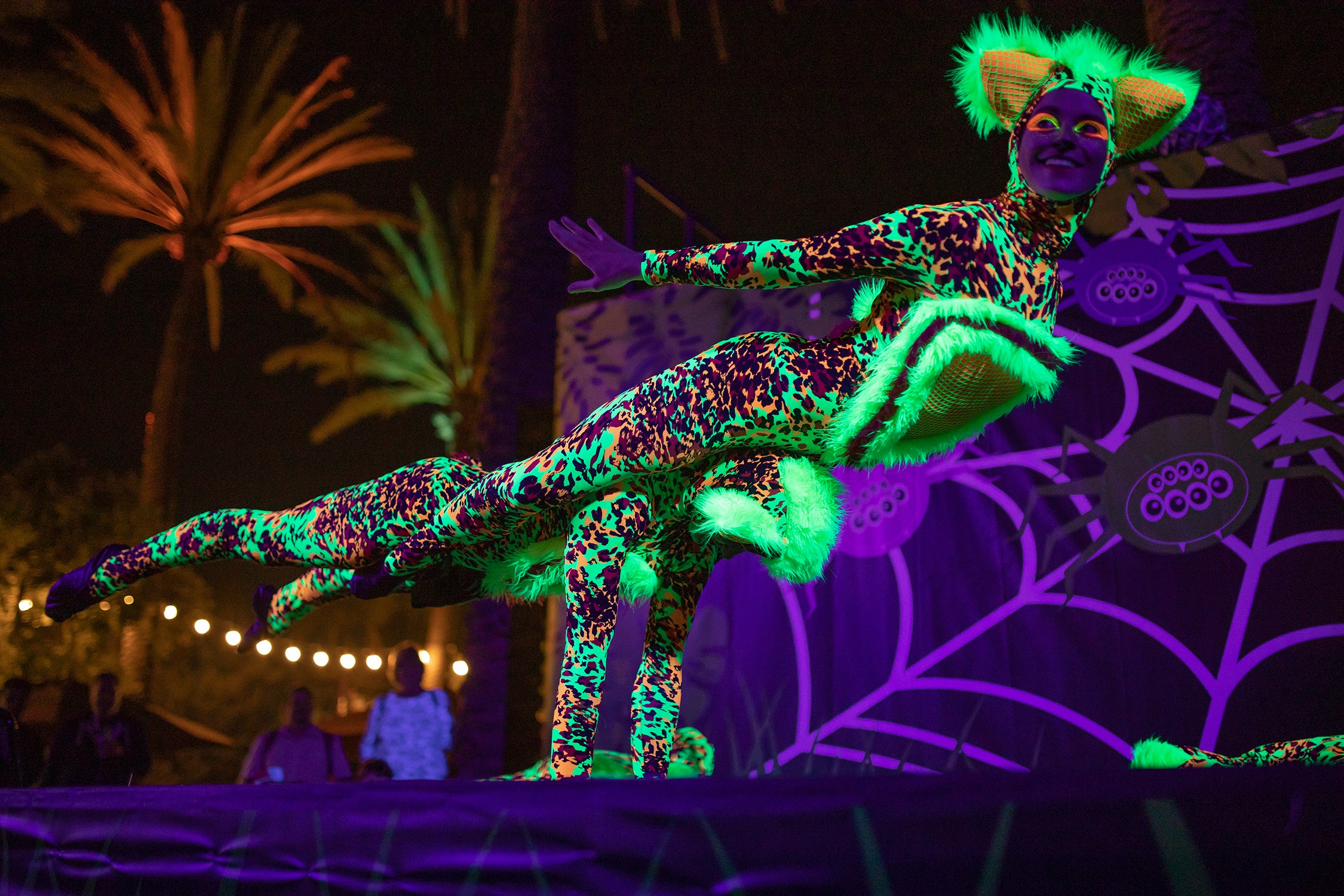 Performer in neon costume at San Diego Zoo's Glowing Character Entertainment event.