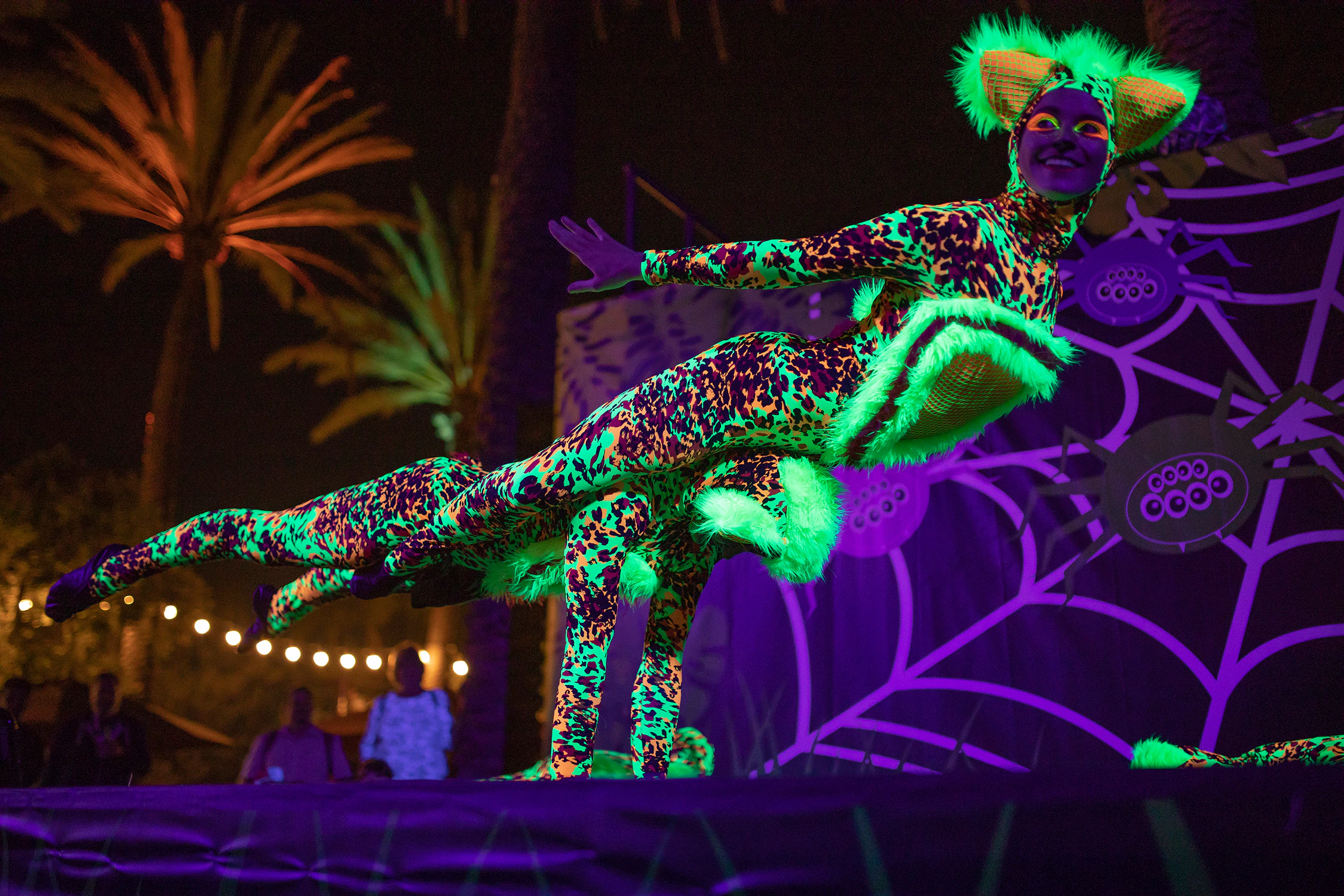 Performer in neon costume at San Diego Zoo's Glowing Character Entertainment event.