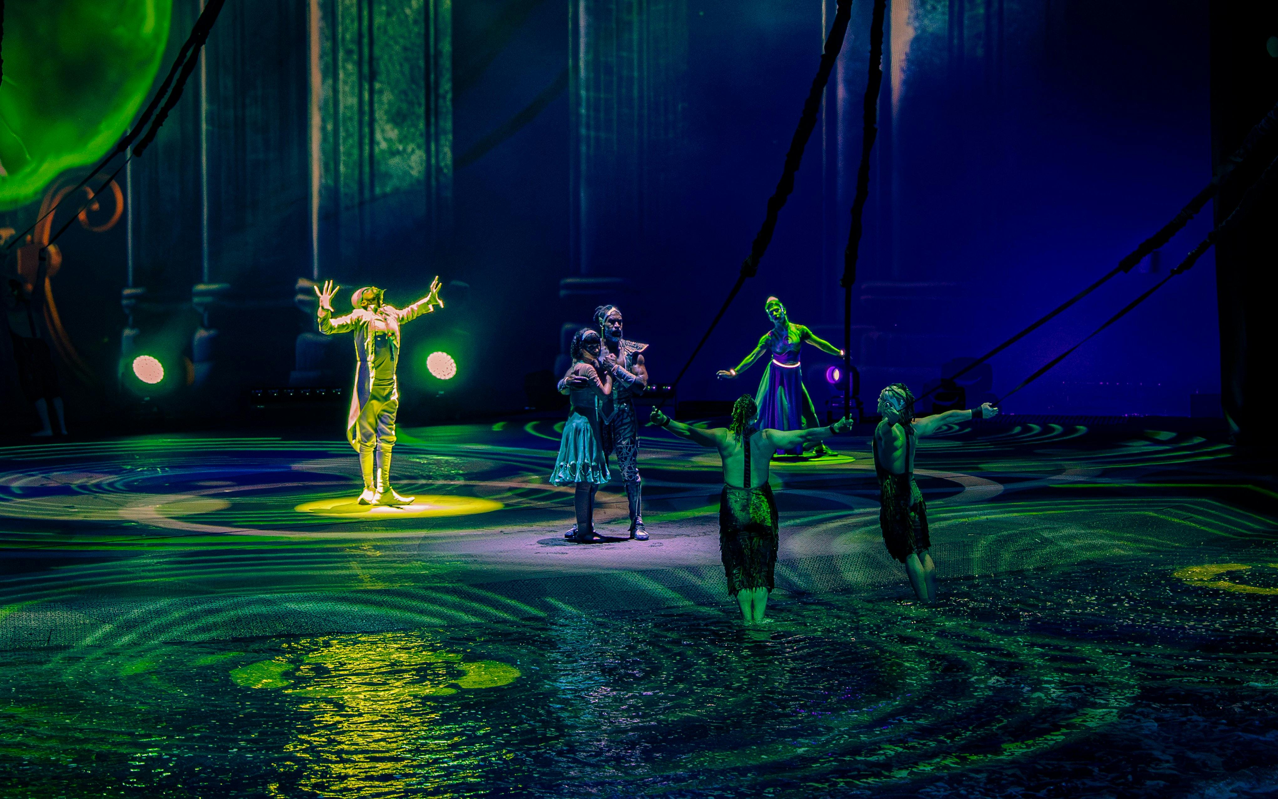Performers on stage during La Perle show in Dubai, featuring acrobatics and water effects.