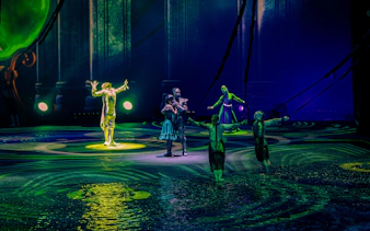 Performers on stage during La Perle show in Dubai, featuring acrobatics and water effects.
