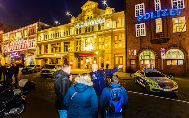 Tour group outside St. Pauli Theater in Hamburg at night.