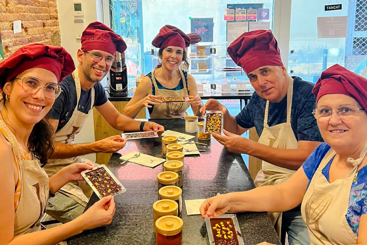 Participants in a chocolate-making class in Barcelona display their handmade chocolate bars.