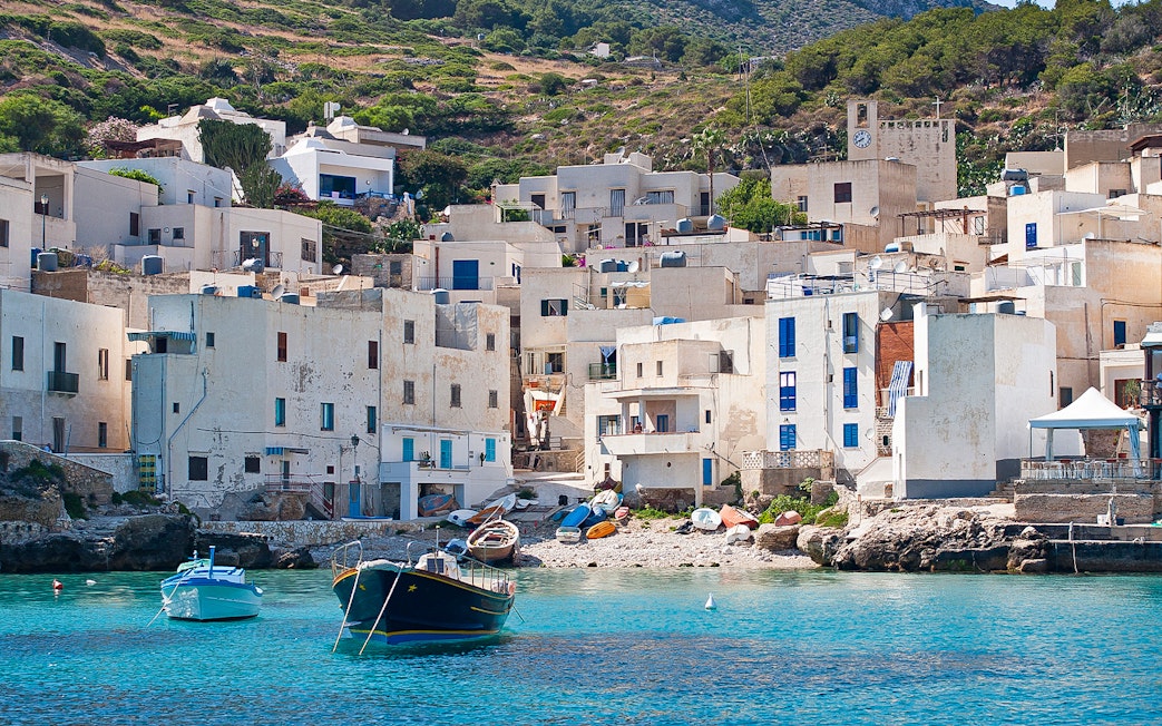 Levanzo town on Egadi Island with white buildings and boats in turquoise water.