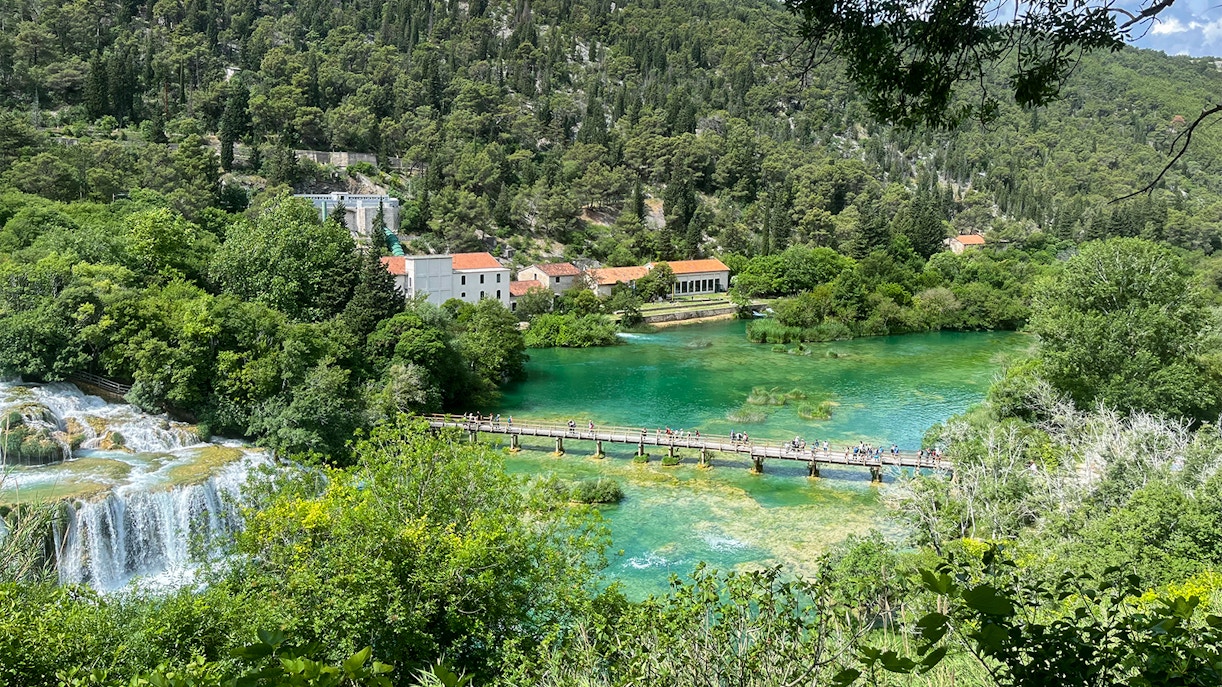 Krka bridge spanning over lush greenery and river at Krka National Park, Croatia.